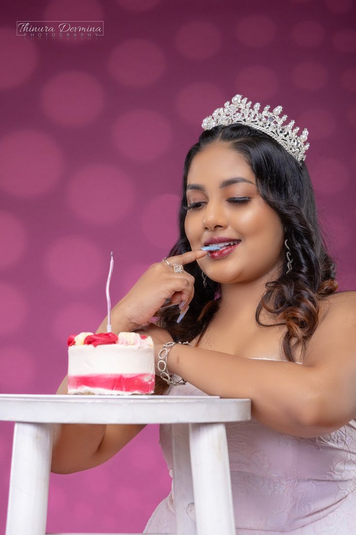 Birthday portrait in a pearl crown beside a small celebration cake